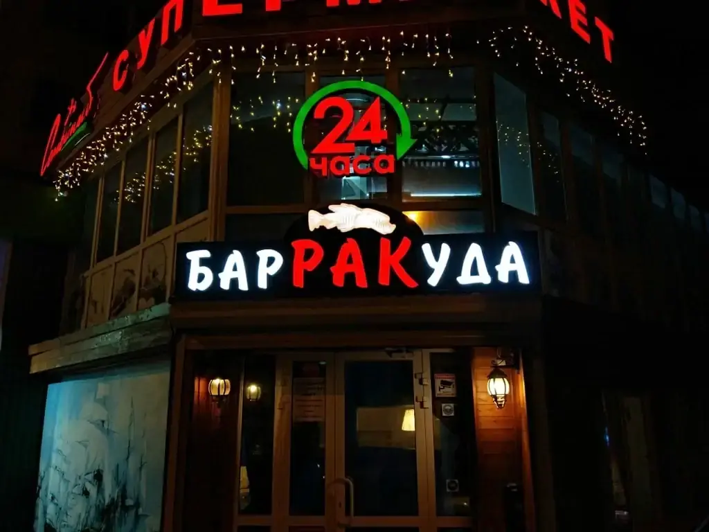 Вывеска таверны «Барракуда+» ночью